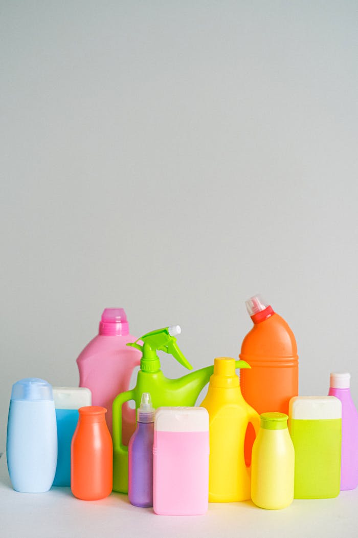 Assorted colorful plastic cleaning bottles on a white background.